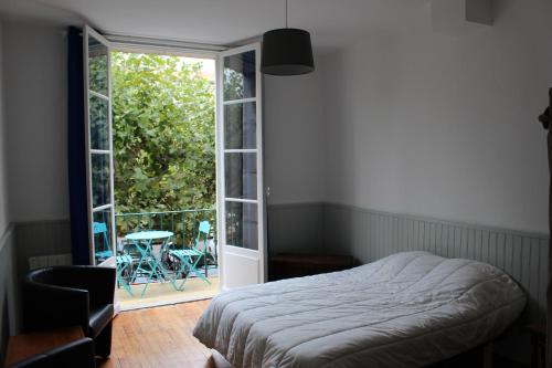 une chambre avec un lit et une porte coulissante en verre dans l'établissement Tout A Pied Au Coeur De Royan, à Royan
