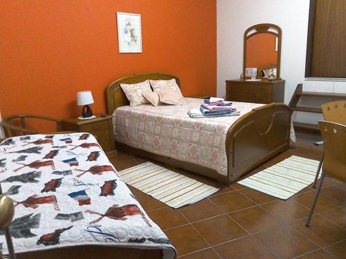 1 dormitorio con cama, mesa y espejo en Edificio Saul Fanha, en Nazaré