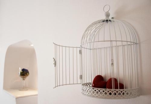 a bird cage with hearts in it on a wall at Reverie Santorini Hotel in Firostefani
