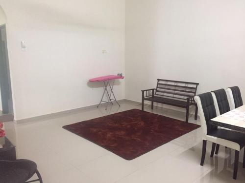 a living room with a table and a red rug at PATIN GUEST HOUSE @DESA TELOK IRA, TEMERLOH PAHANG in Kampong Paya Kerinau