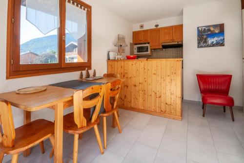 une cuisine et une salle à manger avec une table et des chaises en bois dans l'établissement Marquis 5, à Morzine
