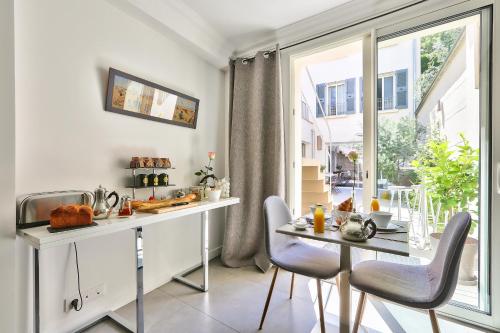 パリにあるル クロ ド ロリビエのテーブルと椅子と窓のあるキッチン