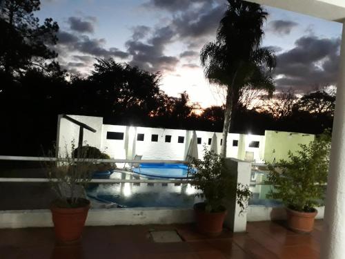 a view of a swimming pool at sunset at Hotel La Posta del Dayman in Termas del Daymán