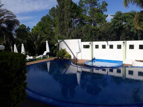 a large swimming pool with a white fence and a white at Hotel La Posta del Dayman in Termas del Daymán
