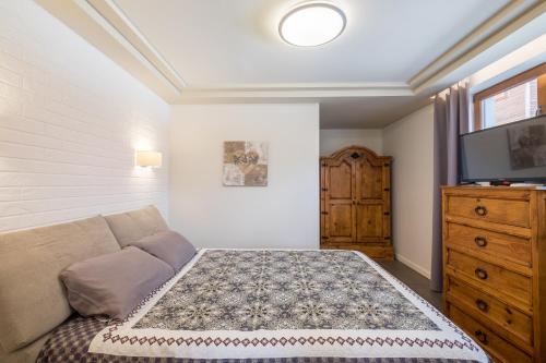 a bedroom with a couch and a flat screen tv at Villa ADELHEIDE - Spa, BBQ & Jacuzzi in Beli Iskar