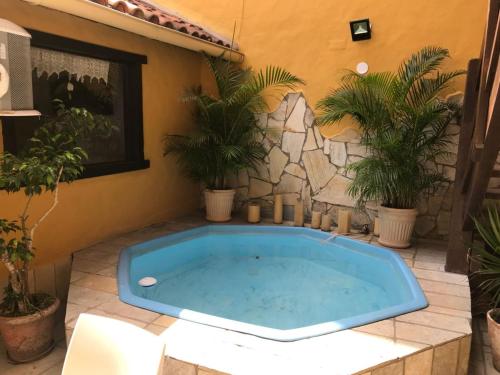 a hot tub in a patio with potted plants at Aquarius Osteria in Arraial do Cabo