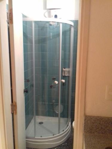 y baño con ducha y puerta de cristal. en Oficina 38, en Punta del Este