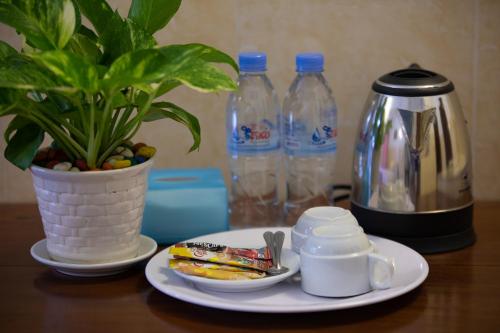 a table with a plate of food and a plant and water bottles at Botoum Hostel in Siem Reap
