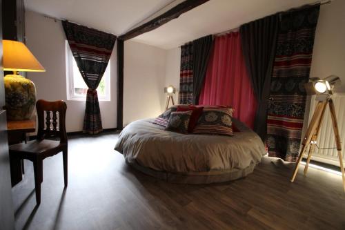 a bedroom with a bed and a table and a chair at Le Pommenial de la Hérissonnière in Saint-Aubin-de-Bonneval