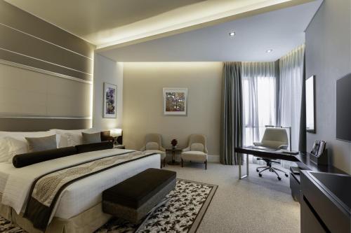 a hotel room with two beds and a television at Grand Millennium Business Bay in Dubai
