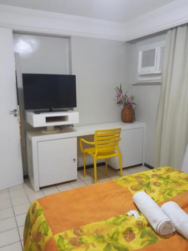 1 dormitorio con 1 cama y escritorio con TV en Flat na Boa Viagem Recife A, en Recife
