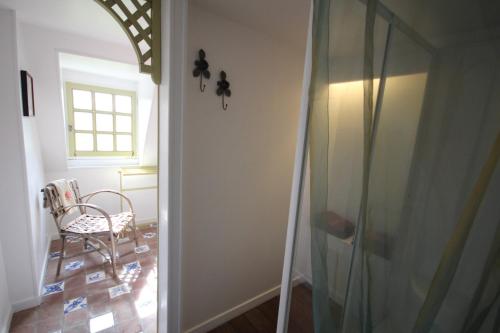 a glass shower door with a chair in a room at Le Pommenial de la Hérissonnière in Saint-Aubin-de-Bonneval