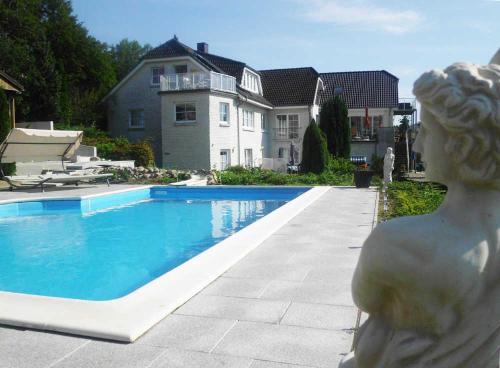 a statue of a woman standing next to a swimming pool at Gaestehaus Vogelsang in Sierksdorf