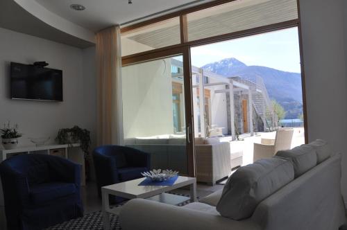 a living room with a couch and a large window at Tullio Hotel in Gravedona