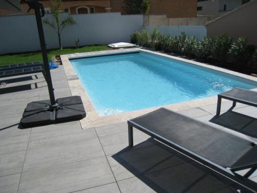 - une piscine avec une table et un banc à côté dans l'établissement VILLA M&M, à La Seyne-sur-Mer