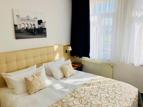 ライプツィヒにあるHotel am Bayrischen Platzのベッドルーム(白い枕の大型ベッド1台付)
