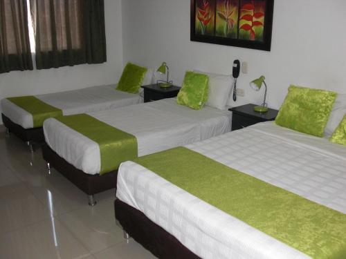 a room with two beds with green sheets at Hotel Aussie koala in Armenia