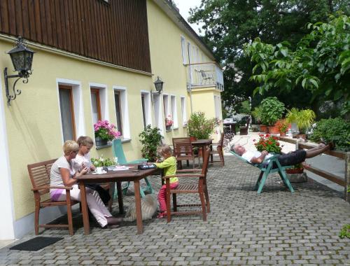 um grupo de pessoas sentadas à mesa em Ferienhof Jungkunz em Schwarzenbach am Wald
