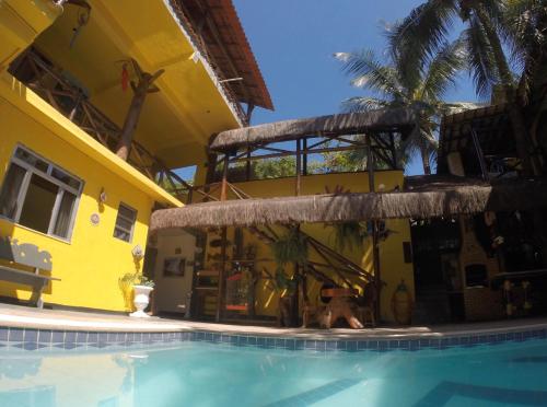 a building with a swimming pool in front of a house at Morada do Aventureiro in Angra dos Reis