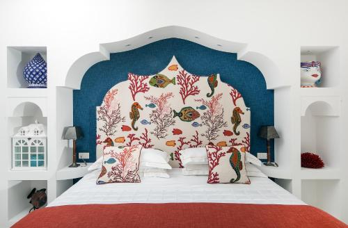 a bedroom with a bed with a blue and white headboard at Hotel Onda Verde in Praiano