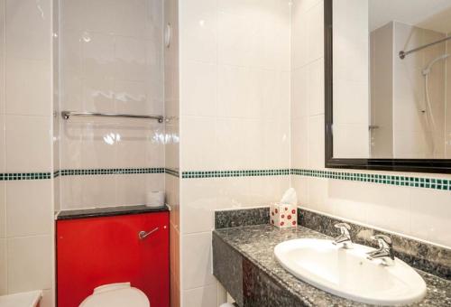 a bathroom with a sink and a toilet and a mirror at Britannia Edinburgh Hotel in Edinburgh
