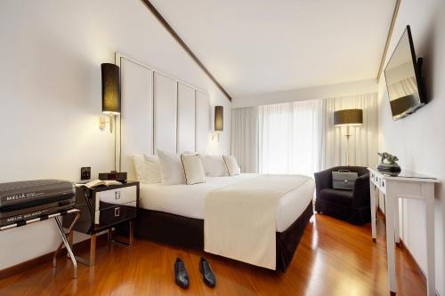 a hotel room with a bed and a television at Meliá Milano in Milan