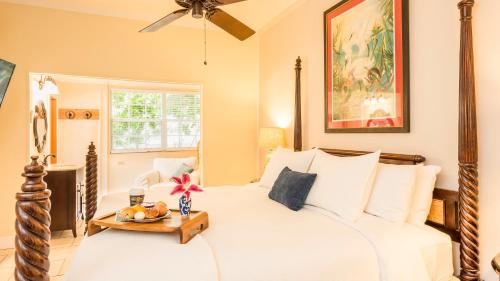 una camera con un letto bianco e un tavolo di L'Habitation Guesthouse- Adult Exclusive a Key West