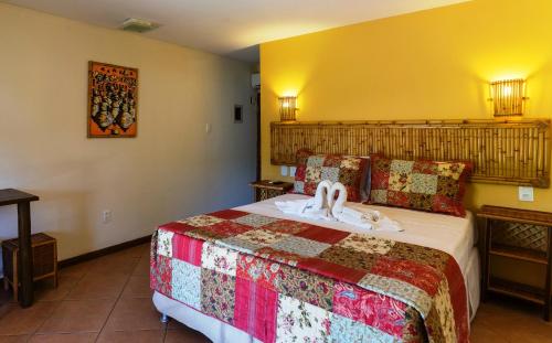a hotel room with a bed with a towel on it at Pousada Praia das Ondas - Pé na areia in Itacimirim