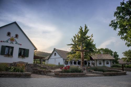 a white building with a tree in a courtyard at Provence Birtok in Decs