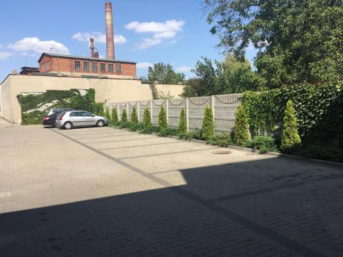 a car parked in a parking lot next to a fence at Apartamenty Dobranocka in Krotoszyn
