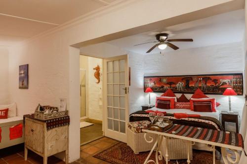 sypialnia z łóżkiem z czerwonymi poduszkami w obiekcie Bamboo, the Guesthouse w mieście Knysna