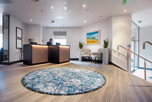 an office lobby with a man standing at the counter at Ten Hill Place in Edinburgh