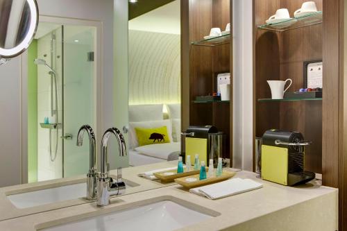 a bathroom with a sink and a mirror at Steigenberger Airport Hotel Frankfurt in Frankfurt/Main
