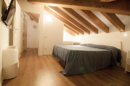 a bedroom with a bed in a room with wooden floors at Holiday home Isola Rossa in Isola Rossa