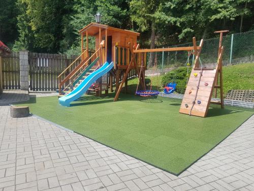 Un parque infantil con un tobogán y un tobogán. en Domek Przy Źródełku, en Muszyna