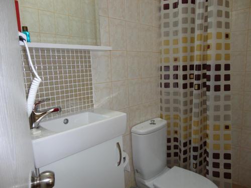 a bathroom with a white toilet and a sink at Olimpiyat Hotel Izmir in Izmir