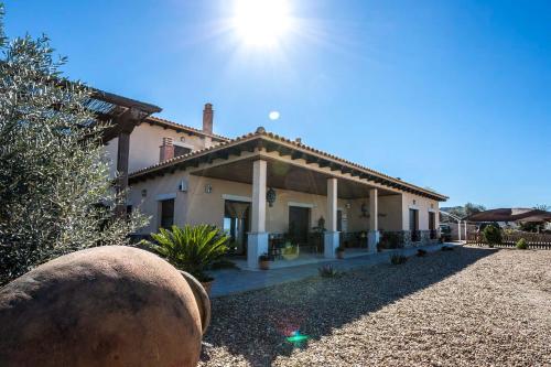une grande maison avec le soleil au ciel dans l'établissement Casa rural la huerta de los nogales, à Herrera del Duque