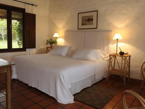 a bedroom with a white bed and a window at Posada de la Laguna in Colonia Carlos Pellegrini