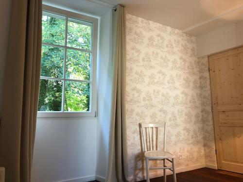 a chair sitting next to a window in a room at La Basse Cour in Tanlay