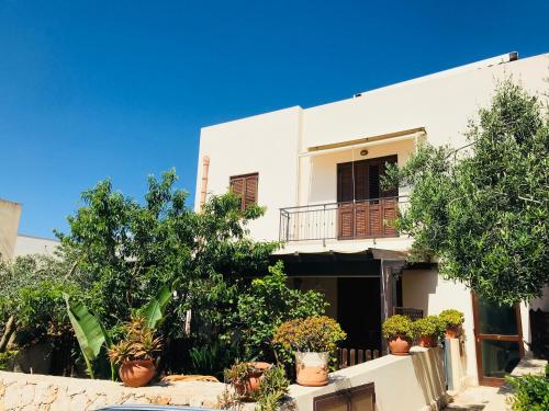 una casa blanca con macetas delante de ella en Appartamento BluOltreMare, en San Vito lo Capo