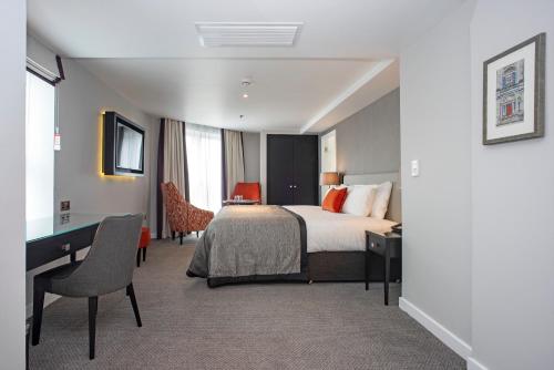 a hotel room with a bed and a desk and chair at Ten Hill Place in Edinburgh