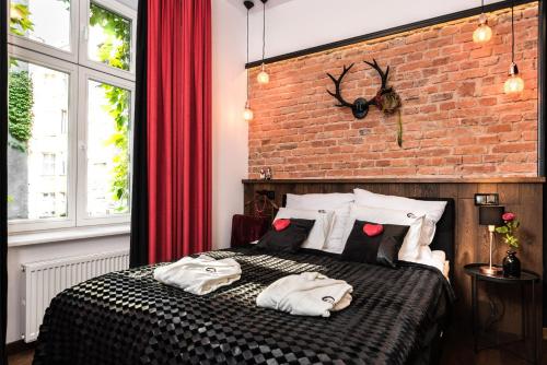 sypialnia z ceglaną ścianą i łóżkiem z poduszkami w obiekcie Wooden Horse - New Apartment - Old Town w Krakowie