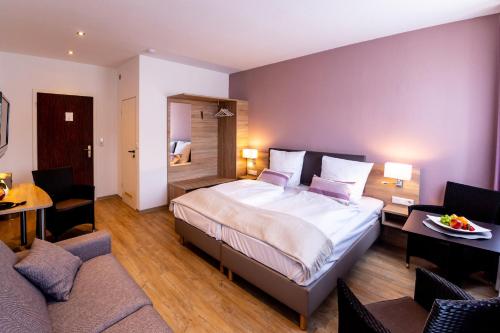 a bedroom with a large bed and a living room at Hotel Restaurant Verst in Gronau