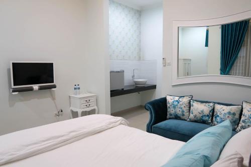 a bedroom with a bed and a chair and a mirror at Griya Suryo Wijilan in Yogyakarta