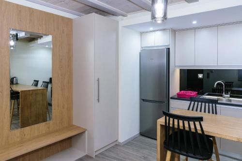 a kitchen with a stainless steel refrigerator and a table at Platanias Aetheras Beach in Plataniás