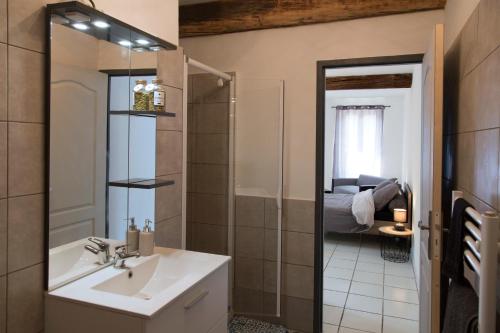 a bathroom with a sink and a mirror and a bedroom at Studio douillet proche de la gare SNCF et du centre in Auxerre