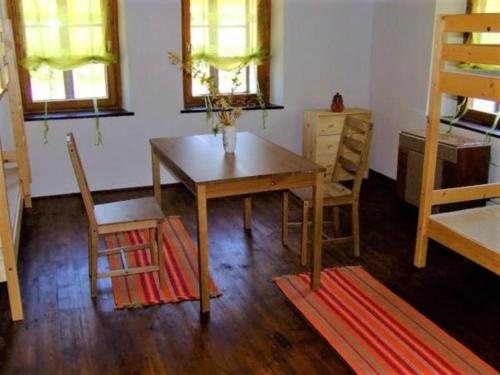 uma sala de jantar com uma mesa e duas cadeiras em Magdolna Vendégház em Szögliget