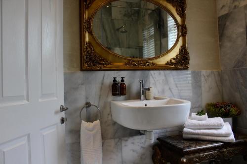 a bathroom with a white sink and a mirror at The Gregoire Boutique Villa in Hermanus