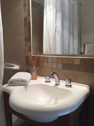 a white bathroom sink with a mirror and a shower at Departamento M&M in San Martín de los Andes