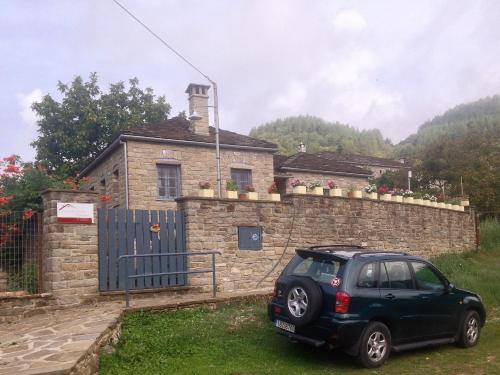a small car parked in front of a stone house at Papigo Stonehouse in Papigko